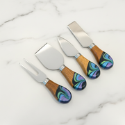 Set of four cheese knives with wooden handles and colorful inlays in a black box.
