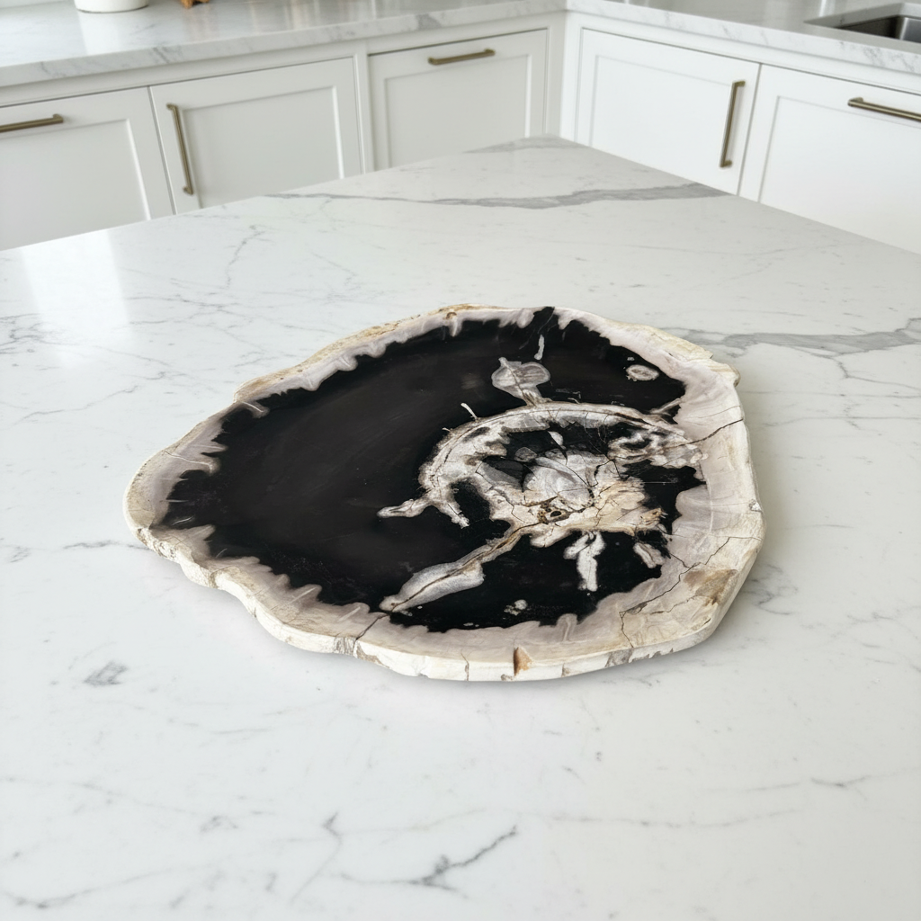 A round petrified wood slab clock face with a black center and white crystalline details, resting on a light gray tiled floor.