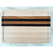Our Maple Edge Grain Cutting Board "The Burton" is a sweet treat for your countertop! Boasting a Sugar Maple base, contrasted with Zebrawood and Wenge horizons, it will make a stylish statement in your kitchen. Its solid build will keep your chopping steady, and it's a unique gift for foodies! Get ready to make a statement with The Burton.